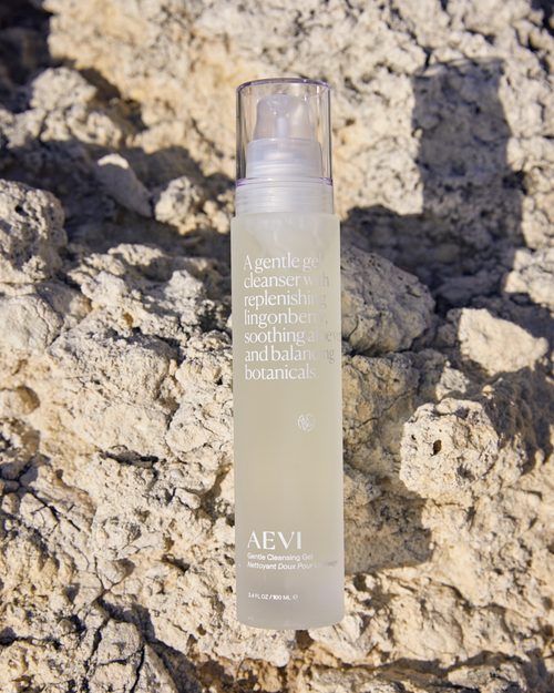 Cleansing gel skincare bottle on a textured stone background